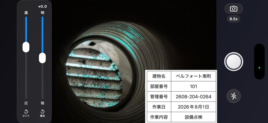 撮影画面。ダクトの奥にある排気ガラリの金網が水色に光っている。左端にピントと露出のスライダーが縦に並ぶ。